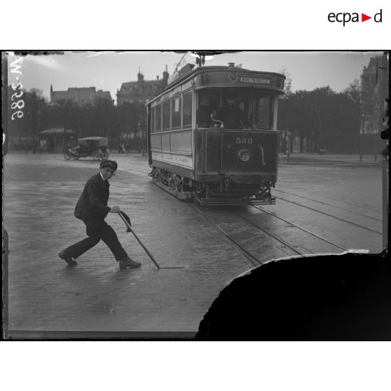 Paris, place de l'Etoile. Un enfant employé à l'aiguillage du tramway. [légende d'origine]