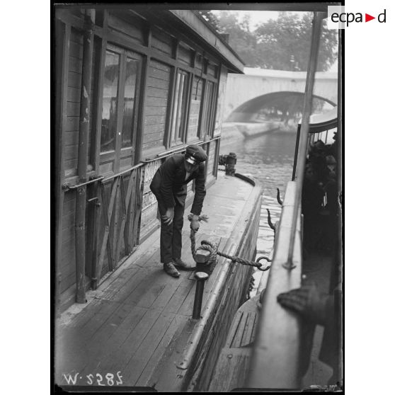 Paris, enfant employé sur les pontons des bateaux-mouches. [légende d'origine]