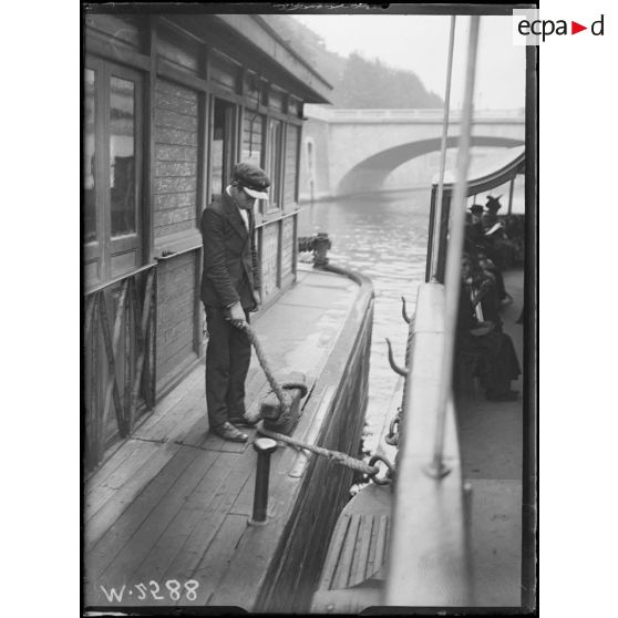 Paris, enfant employé sur les pontons des bateaux-mouches. [légende d'origine]