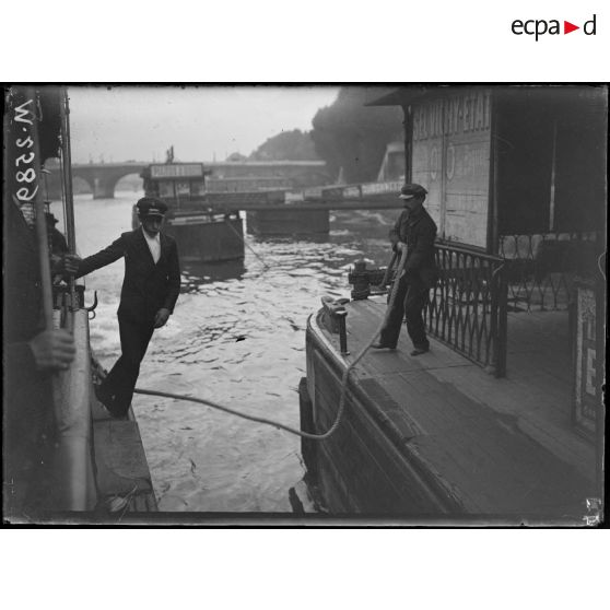 Paris, enfant employé à l'amarrage des bateaux-mouches sur les quais de la Seine. [légende d'origine]