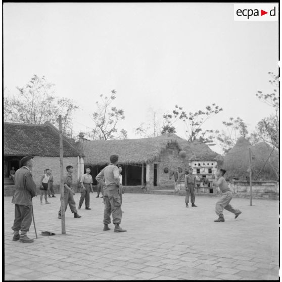 Partie de volley-ball pour les recrues muong sous la direction d'un lieutenant.