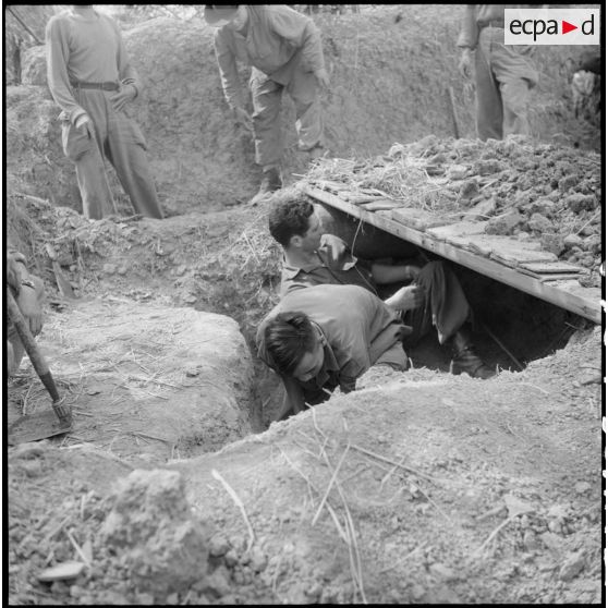 Préparation d'une tranchée de défense par des recrues muong.
