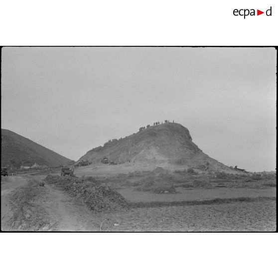 Des camions chargent des matériaux dans une carrière pour l'aménagement du terrain d'aviation de Kien An.