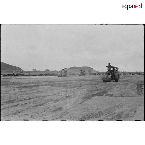 Des rouleaux compresseurs aplanissent le terrain sur le chantier de construction du terrain d'aviation de Kien An.