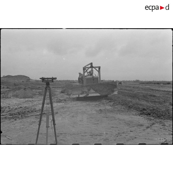 Un sapeur du génie est installé sur un bouteur lors des travaux de construction du terrain d'aviation de Kien An.