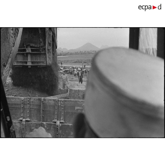 Pelle mécanique conduite par un sapeur du génie lors des travaux d'aménagement du terrain d'aviation de Kien An.