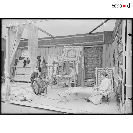 Jardin des Tuileries. Exposition de la cité reconstituée. Atelier travaux de femmes. Assistance aux victimes de la guerre. [légende d'origine]