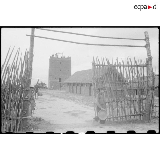 Travaux et construction d'une tour au poste de Trung Xa. L'entrée du poste est protégée par des palissades.