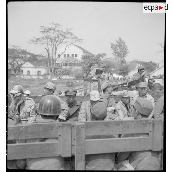 Embarquement des soldats nationalistes chinois internés à bord de camions GMC à destination du port de Haïphong où ils vont embarquer à bord du cargo Docteur Roux.
