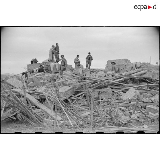 Des soldats fouillent les décombres d'un poste en ruines au Tonkin.
