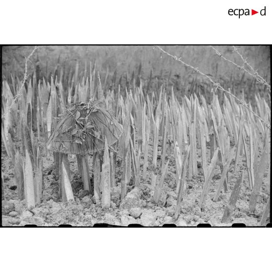 Un casque de soldat du Viêt-minh repose sur les défenses d'un poste du Tonkin après les combats.