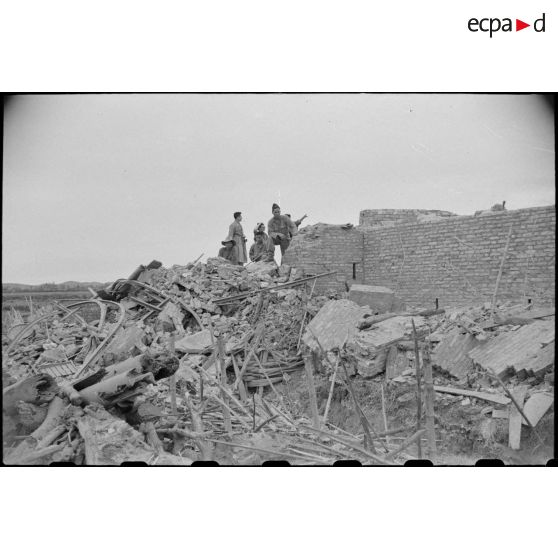 Des soldats fouillent les décombres d'un poste en ruines au Tonkin.