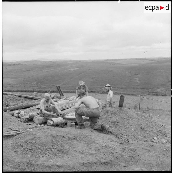 Près du village de Dinh Loc, des légionnaires sont en train de scier un tronc d'arbre.