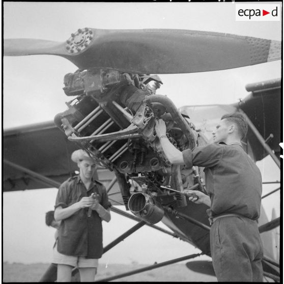 Révision du moteur d'un avion Morane-Saulnier avant le départ en mission du groupe d'aviation d'observation d'artillerie (GAOA) dans le delta du Tonkin.