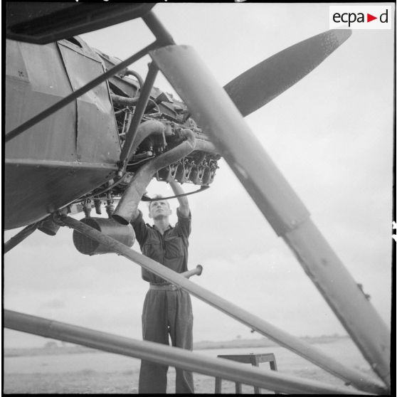 Révision du moteur d'un avion Morane-Saulnier avant le départ en mission du groupe d'aviation d'observation d'artillerie (GAOA) dans le delta du Tonkin.