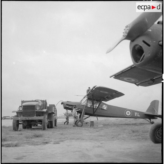 Ravitaillement en essence d'un avion Morane-Saulnier avant le départ en mission du groupe d'aviation d'observation d'artillerie (GAOA) dans le delta du Tonkin.