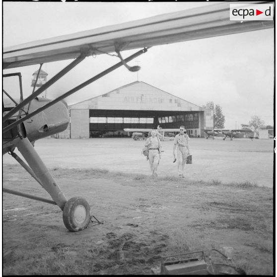 Un pilote et un observateur rejoignent un avion Morane-Saulnier avant de partir en mission dans le delta du Tonkin.
