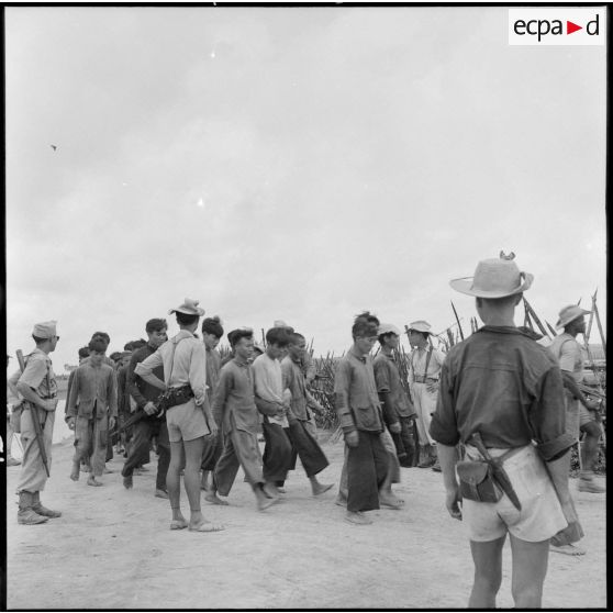 Prisonniers viêt-minhs ligotés sous la surveillance de tirailleurs sénégalais.