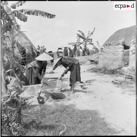 Les habitants du village bouchent les trous individuels creusés par les viêt-minhs.