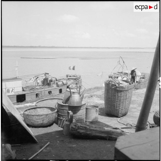 Un bateau destiné au transport des civils vu de la berge du fleuve Rouge.