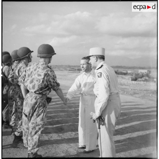 Son Excellence Malcolm Mac Donald, en compagnie du général de Lattre, sert la main à un défenseur de Vinh Yen.