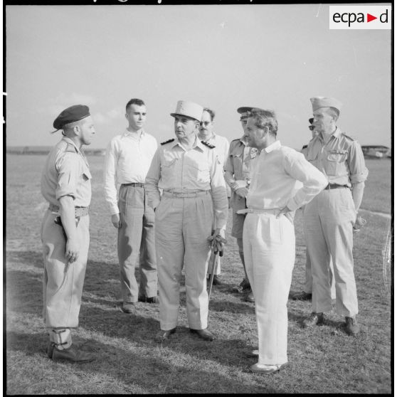 Son Excellence Malcolm Mac Donald et le général de Lattre en compagnie d'officiers, de journalistes et d'officiels.