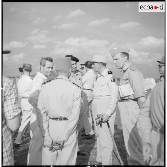 Son Excellence Malcolm Mac Donald et le général de Lattre en compagnie d'officiers, de journalistes et d'<br>officiels.