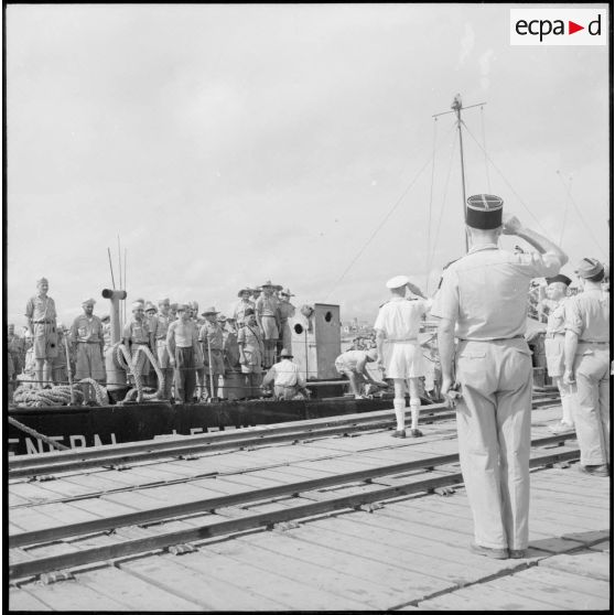 Accostage du LCM "L'inspecteur général Lefevre" ; salut des officiers de marine et de l'armée de terre.