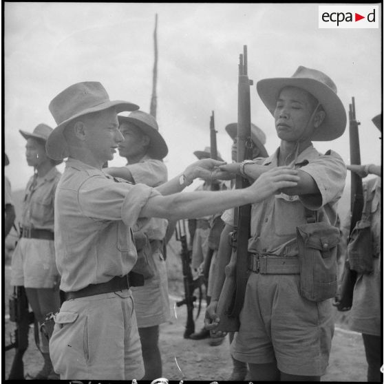 Un officier montre à un soldat comment exécuter le "présentez-armes".