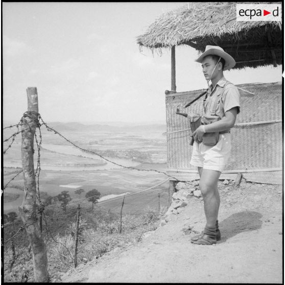 Un soldat du 3e bataillon du 21e RIC, arme au poing, montant la garde.