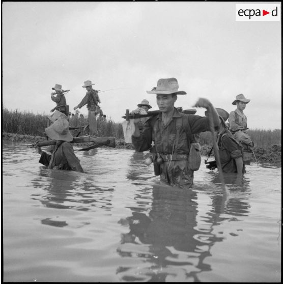 Progression dans un rach, les armes sur l'épaule.