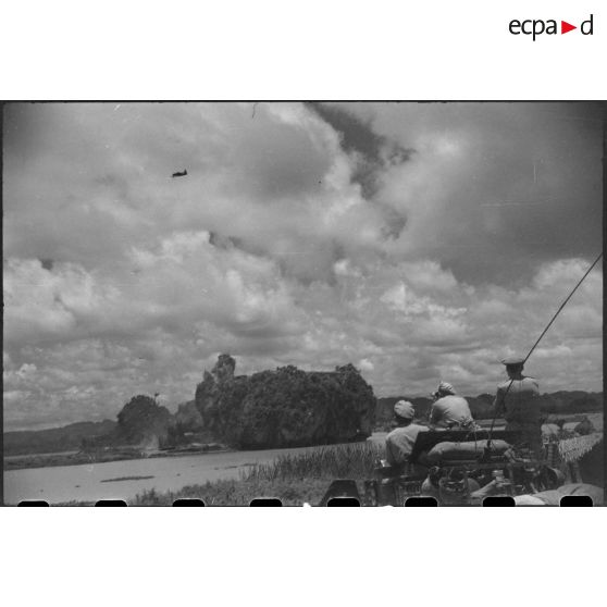 Tir d'un blindé sur un objectif au delà d'un plan d'eau.