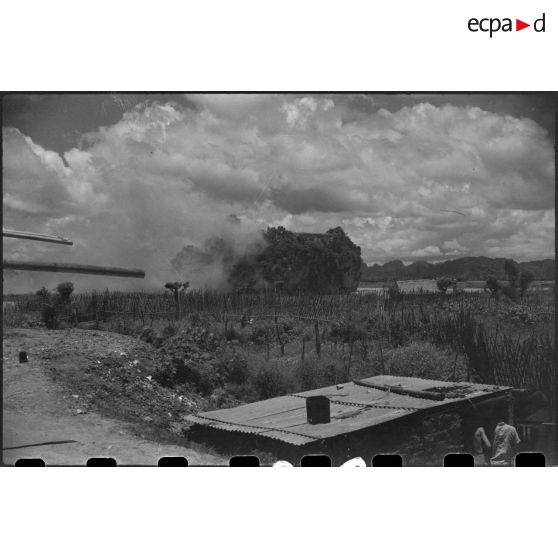 Tir d'un blindé sur un objectif au delà d'un plan d'eau.