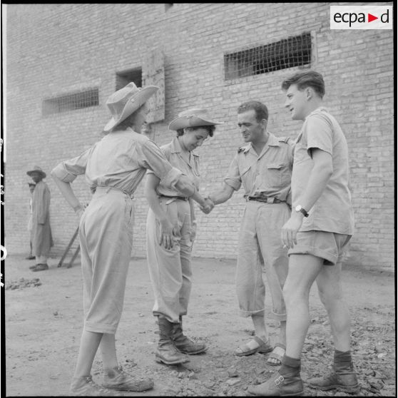 Poignée de main entre assistantes sociales et officiers.