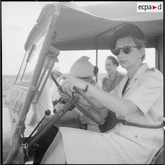 Une assistante sociale au volant d'une jeep.