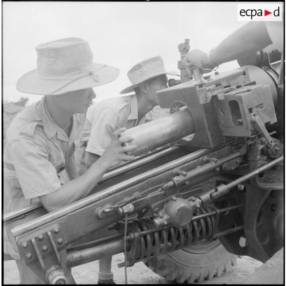 Mise en place d'un obus dans la culasse d'un canon de 105.