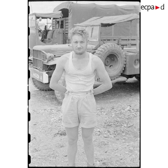 Un soldat pose pour le photographe devant des véhicules, un Dodge T223 WC62 et un GMC CCLW 353.