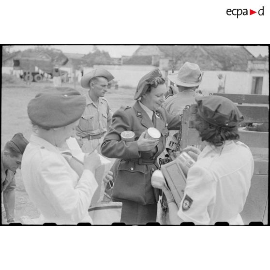 Déchargement de colis et boites de conserve par le personnel féminin.