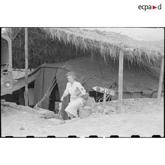 Le personnel féminin sort d'une des cabanes du camp.