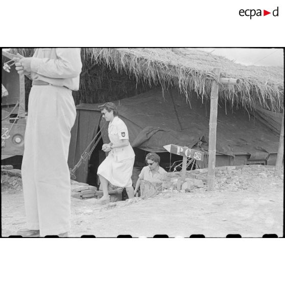 Le personnel féminin sort d'une des cabanes du camp.