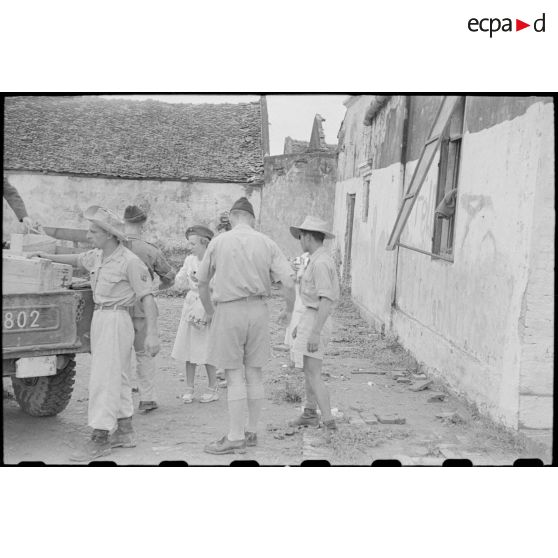 Déchargement de colis et boites de conserve par le personnel féminin.