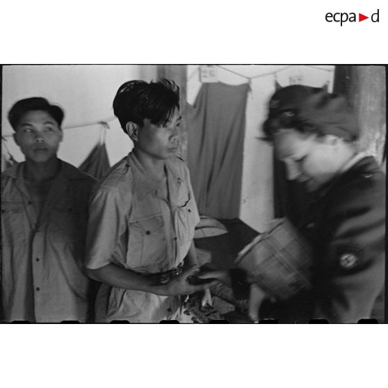 Un vietnamien reçoit un colis des mains d'un personnel féminin.