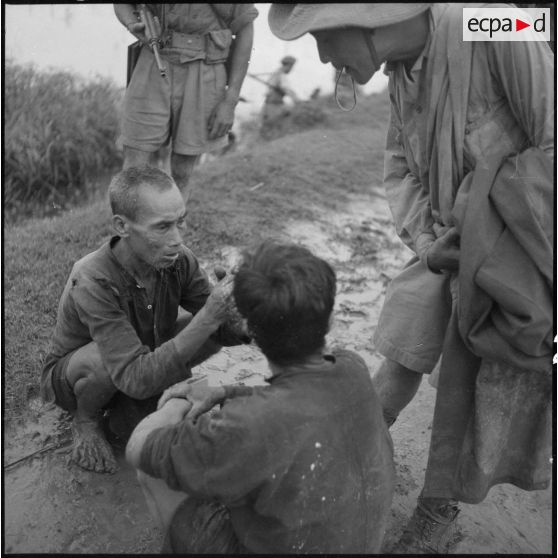 Deux prisonniers viet-minhs surveillés par des tirailleurs.