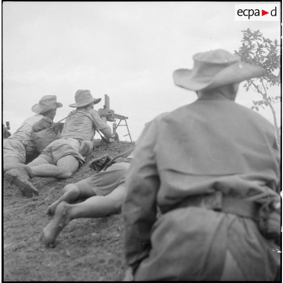 Tirailleurs en position de combat allongés contre un talus.