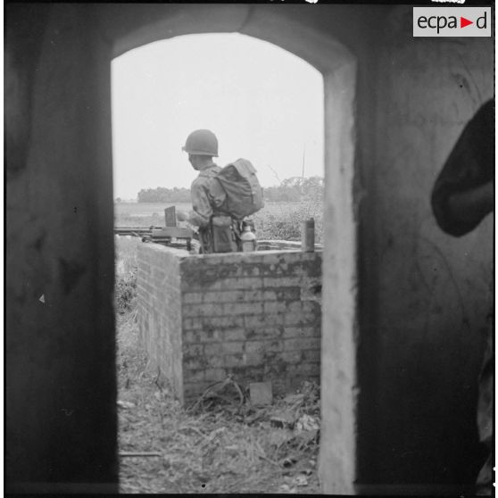 Dans un poste de guet, un soldat du 7e BPC muni d'une arme automatique.