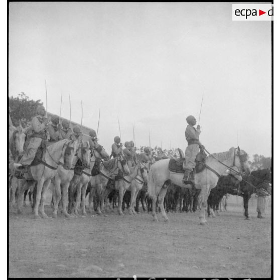 Spahis au présentez-armes sur leurs montures.