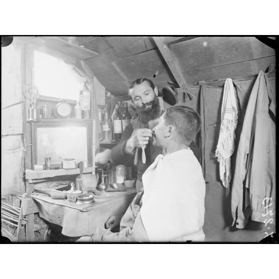 Près de la ferme du Goulot (environs de Jonchery-sur-Marne, Marne). A l'intérieur d'une cagna, un barbier. [légende d'origine]