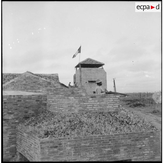 Sentinelle en faction dans un poste, armée d'un fusil MAS 36.