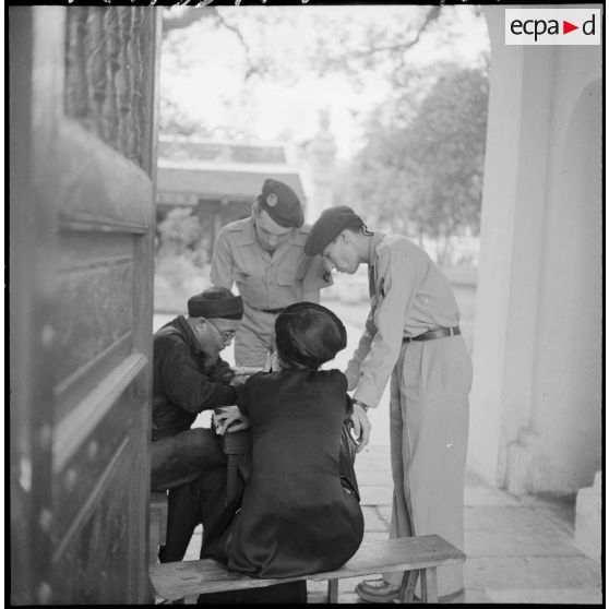 Militaires français du 6e bataillon de parachutistes coloniaux, rencontrant des civils, à Hanoï.