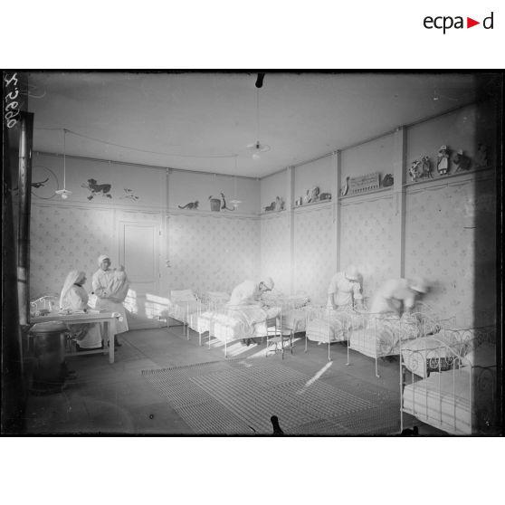 Paris. Pouponnière du camouflage (passage de l'Atlas). Jeunes fille bénévoles soignant les bébés. [légende d'origine]